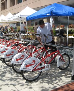 Washington's SmartBike system, launched this month, features 10 locations, computerized racks, and $40 annual memberships. Results of a Philadelphia bike-share study are due by year's end.