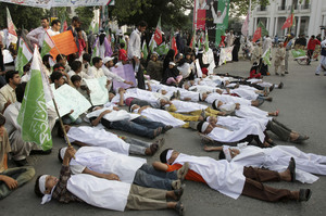 Shiite Muslim youngsters lie on the road in Lahore, Pakistan, during a rally against the killing of Shiites in sectarian fighting.