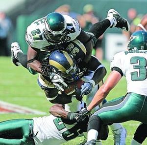 Eagles' Quintin Mikell (27) and Lito Sheppard bring down Rams' Steven Jackson.