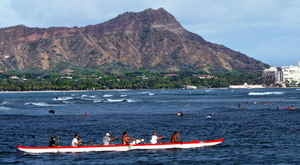 Paddlers power an outrigger canoe near Waikiki. Higher airfares are keeping visitors away, prompting hotels to cut their rates.