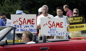 Protesters in Colts Neck watch traffic as they stand along a road near the private fund-raiser where President Bush came to raise money for Republican congressional candidates Chris Myers in the Third District and Leonard Lance in the Seventh District.
