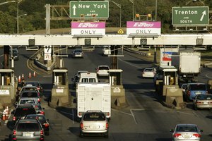 Cars at the toll booths on the N.J. Turnpike in East Brunswick. Funds from the higher tolls will finance widening sections of the turnpike and parkway, among other projects.
