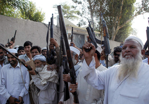 Tribesmen brandish their weapons in Daudzai, near Peshawar, Pakistan. Some analysts question the effectiveness of the often ramshackle forces against an increasingly brutal insurgency.