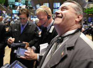 A skyrocketing market rally evoked a smile from trader Thomas Riley (right) on the New York Stock Exchange floor yesterday. The Dow rose more than 900 points, a gain of 11.1 percent.