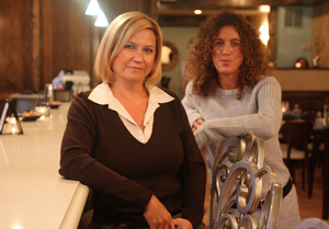 West Conshohocken restaurant owners Marianne Gere (left) and Kim Strengari wait tables and tend bar at Stella Blu and Gypsy Saloon. They have also cut their own pay.