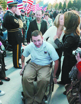 Marine Sgt. Andrew Robinson and wife Sara make their way up their new driveway past the crowd honoring him. They were given keys to a wheelchair-accessible home in Florence.