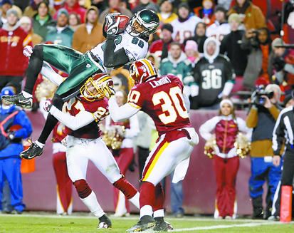 The Eagles' Reggie Brown is stopped just short of the goal line by the Redskins' Fred Smoot and LaRon Landry as time runs out. Brown caught a 17-yard pass.
