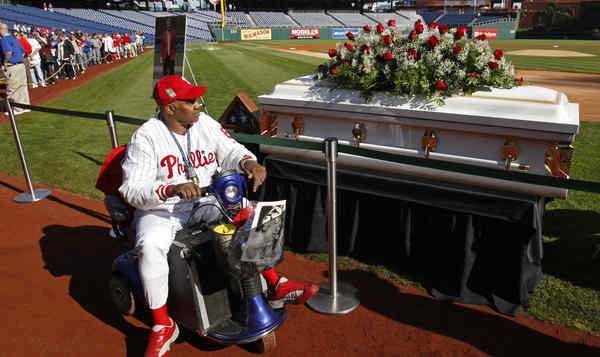 Philadelphia Phillies players pass along the casket of their long