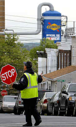 Crossing guard Thelma Van Horn works outside Linwood school next to refinery.