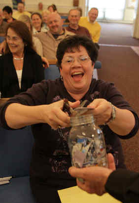 Dawn McMichael cuts her credit cards into a mason jar during a Financial Peace University session at the Malvern Bible Chapel in Malvern. "This is the painful moment," she said.