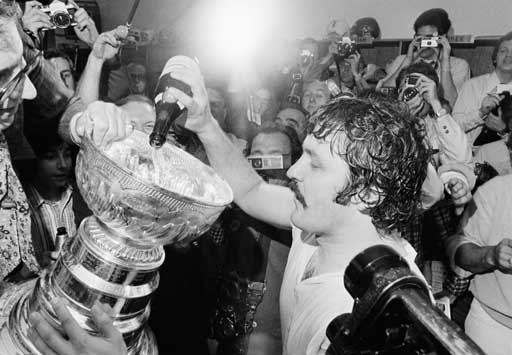 Philadelphia Flyers celebrate on the ice after winning the NHL Stanley cup  by beating the Boston Bruins in Philadelphia, May 19, 1974. Flyers center  Bobby Clarke, left, and goalie Bernie Parent, right, hold the trophy as  they celebrate. (AP Photo Stock