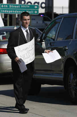 RUTGERS GRAD Andrew J. O&acute;Malley (above) and La Salle grad Sean Christman, both looking for work, hand out their resumes to passing cars at the Ben Franklin Bridge yesterday. It could work - it did 20 years ago. 