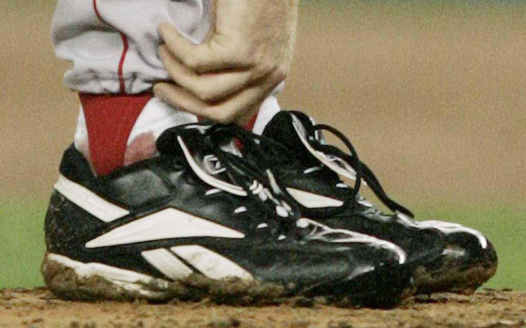 Philadelphia Phillies starting pitcher Curt Schilling covers his head with  a towel in the dugout after Mitch Williams took over from him in the ninth  inning of game 5 of the National