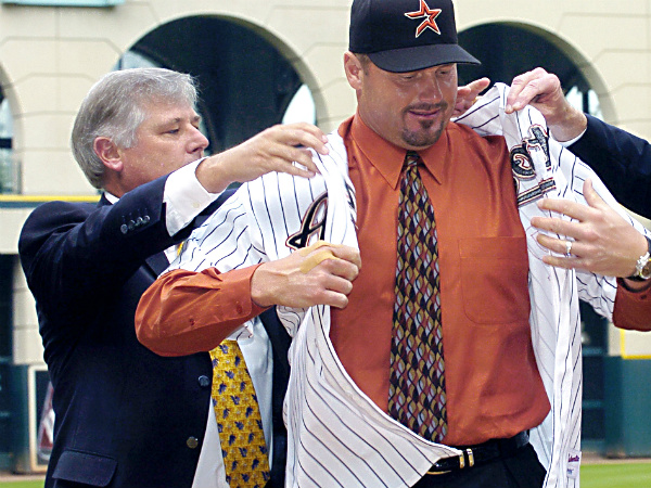 Houston Astros general manager Gerry Hunsicker, right, helps