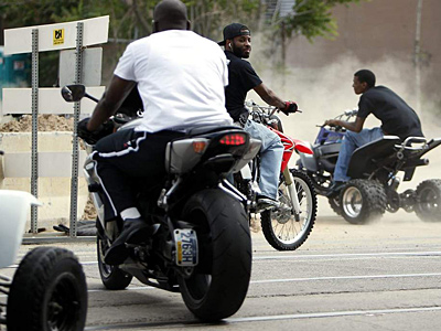 Dirt bike rider Mike Miles (center) rides along Richmond Street. (David Maialetti/Staff)