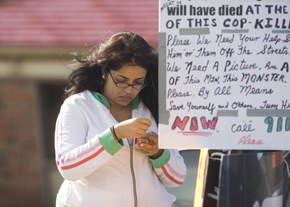 Selvia Wissa, who says officer Cassidy responded when she was shot, leaves a card and placard at a makeshift memorial outside the Dunkin Donuts at 66th Ave and Broad Street.
