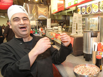 Performance artist Robert Karimi as chef Mero Cocinero Karimi offers a Reading Terminal merchant some "picados unidos." His shows Thursday through Saturday at the Asian Arts Initiative use cooking, song, storytelling, and comedy to teach about preventing Type 2 diabetes. CHARLES FOX / Staff Photographer