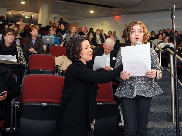 Little Angelina Chila, an 8-year-old third grader at Hurffville Elementary School, addresses the commission at Camden County College in Blackwood on Feb. 19, 2015. Angelina´s mom, Carol, is holding the microphone. They live in Sewell. ( CLEM MURRAY / Staff Photographer )