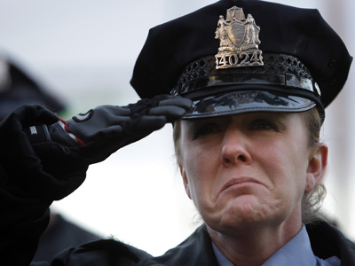 Police Sgt. Timothy Simpson was killed in a car crash.  Police say William Foster, of Levittown, (right) caused the accident. Officer Kathleen DeNofa salutes during at a vigil for Simpson. (AP)