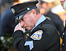 A police officer wipes away tears at the burial of fallen police office Charles Cassidy at Holy Sepulchre Cemetery.
