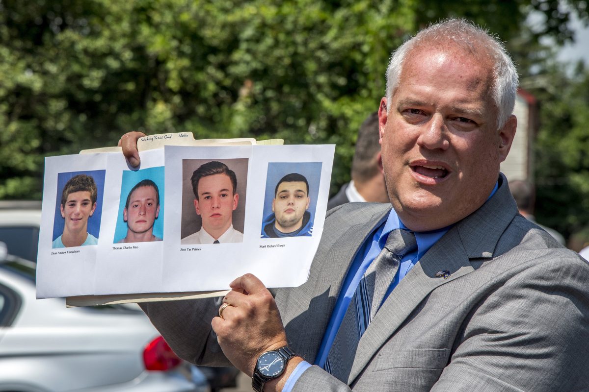 Bucks County District Attorney Matthew Weintraub holds up photos of four young men who are missing. 