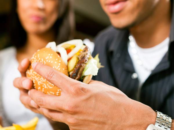 His girlfriend sure wishes he looked at her the same he does that burger.