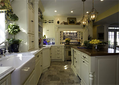 The use of Carrera Marble counter tops, tumbled stone flooring, and dual- toned cherry wood and soft yellow cabinetry makes for a harmonious feeling for what will be the busiest room of the home. 
