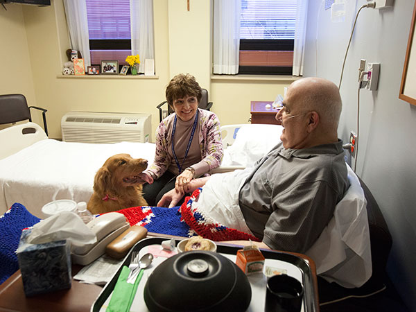 Delores Esposito and her border collie, Daisy, visit with hospice patient Bertram Levy, 81, at Holy Redeemer Hospice in Abington Monday, Feb. 17, 2014. (ED HILLE / Staff Photographer)