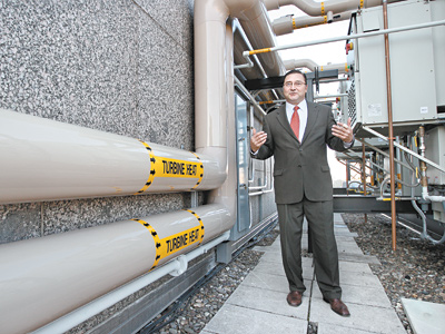 Marvin Dixon, the director of engineering at the Four Season, stands next to the pipes that take water to the roof to be heated by the turbines and then take it back to be used in the hotel. (Michael Bryant / Staff Photographer)