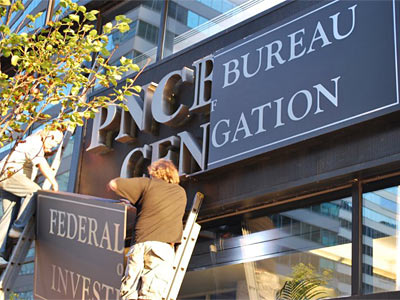 Workers change the sign on the PNC Bank Center for a film crew. ( ROSS IRWIN / Inquirer)