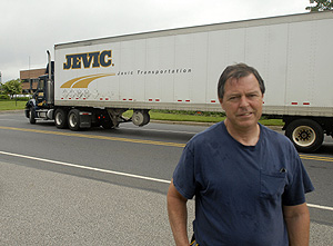 George Meehan, a truck driver for Jevic, with a company truck rolling by behind him in Delanco. The company announced Monday that it was closing.<br />