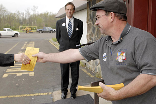 Republican poll worker George Dranginis, a committeeman and alternate delegate to the national convention, passes out sample Republican ballots outside a polling place inside the Knights of Columbus hall on Woodbourne Road in Levittown.