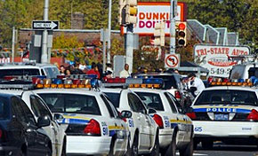 Police converge at the Dunkin' Donuts at Broad Street and 66th Avenue where a police officer was shot and seriously wounded as he confronted a gunman.
