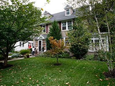 David and Carole Alfe stand in front of their Colonial Revival house, which was built in 1923.