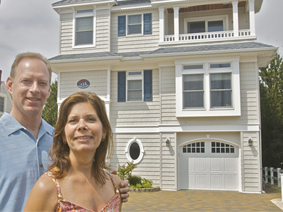 Adrienne Drost with her husband, Joe, outside their Shore home in North Beach Haven. The Drosts remade a 50-year-old Cape, which was literally sinking into the sand. The remade home came with a new foundation. (John Costello / Staff Photographer)