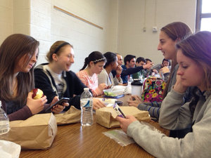 Students at lunch on Facebook on their cell phones and conversing face-to-face. Credit Meghan Miller<br />